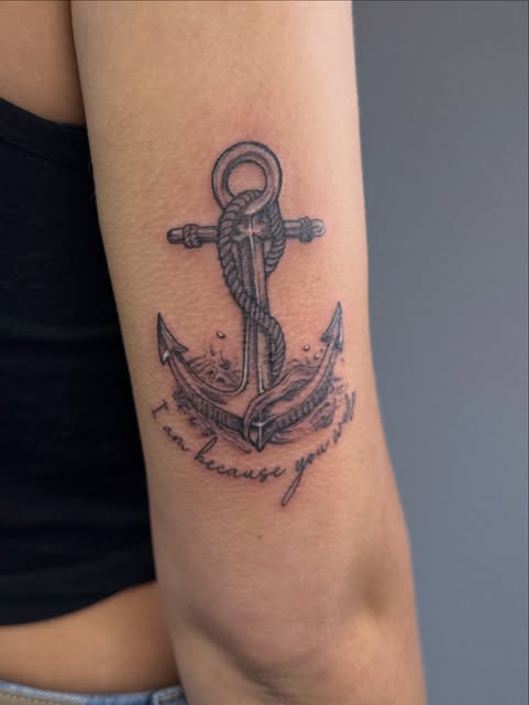 Illustrative anchor wrapped in rope with a script banner on the back of the arm